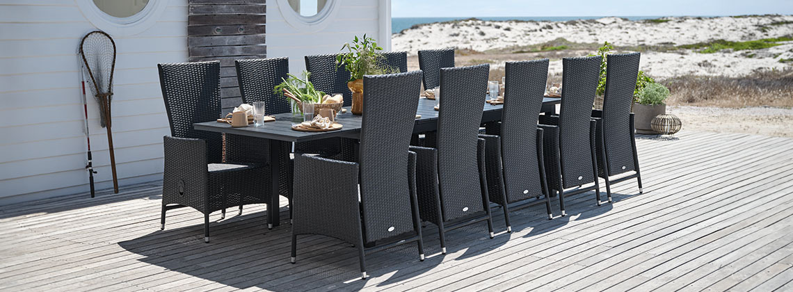 Mesa de jardín grande y sillas para 10 o 12 personas en una terraza frente al mar 